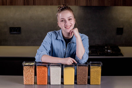 Woman organizing food in the kitchen with containers.の写真素材