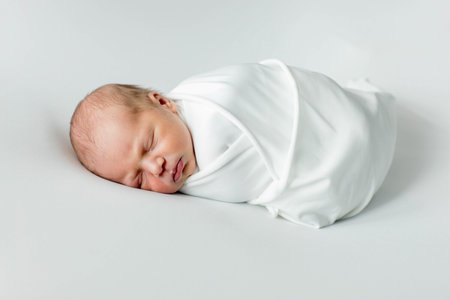 Close up of cute newborn baby sleeping on white background covered.Care,love,happiness conceptの写真素材
