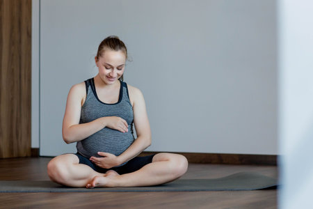Happy beautiful pregnant woman before exercising at home.