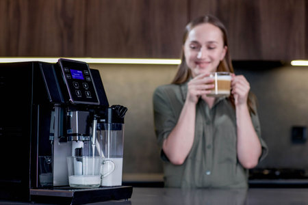 Female enjoying of fresh coffee aroma after brewing coffee using coffee maker in the kitchen at homeの写真素材