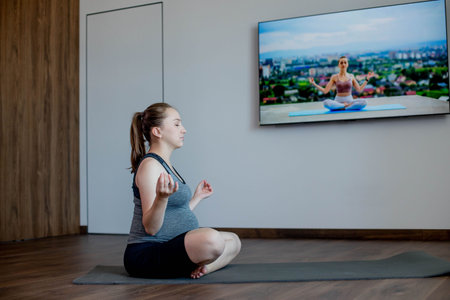 Pregnant woman practicing yoga at home.の写真素材