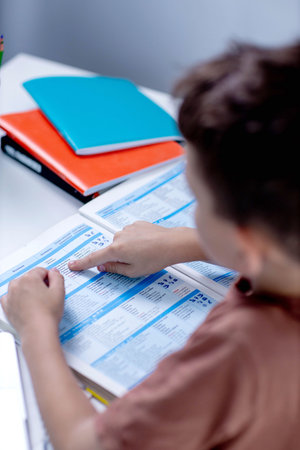 Boy reading book at the table at home.の写真素材