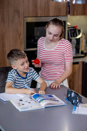 Mother Helping Son With Homework At Table.の写真素材