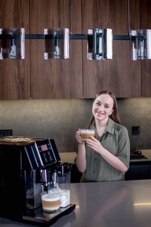 Female enjoying of fresh coffee aroma after brewing coffee using coffee maker in the kitchen at homeの写真素材