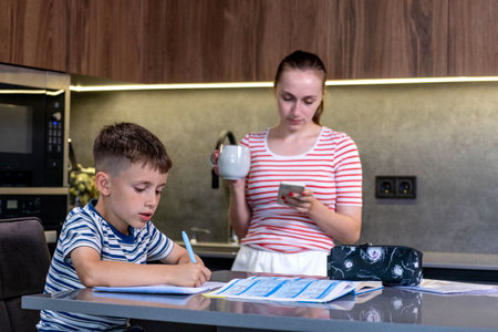 Mother Helping Son With Homework At Table.の写真素材