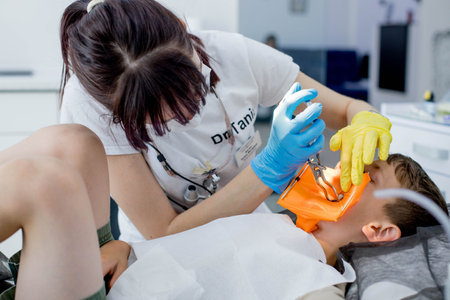 Process of installing a dental cofferdam for dental treatment on child.の写真素材