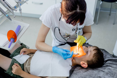 Dentist treats the child's tooth using a rubber damの写真素材