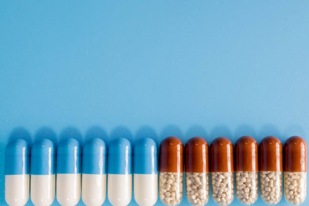 Mixture of medical capsules in a line on a blue background top view. Dietary supplements, copy spaceの写真素材
