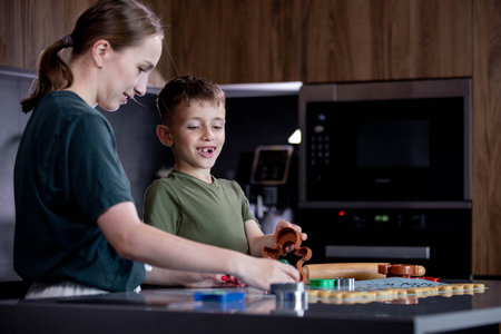 Mother and son are cooking cookies together in the kitchen.の写真素材