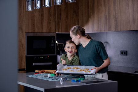 Mother and son baking cookies in the kitchen at home. Concept of friendly family.の写真素材