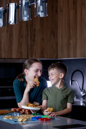 Mother and her son eating freshly baked gingerbread together.の写真素材