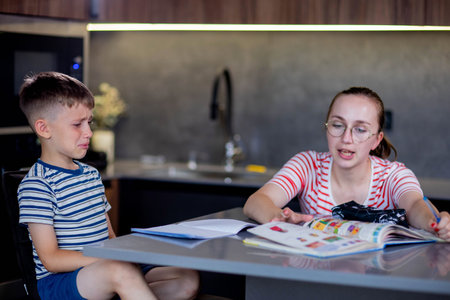 Mother helping her son doing homework in kitchen.の写真素材