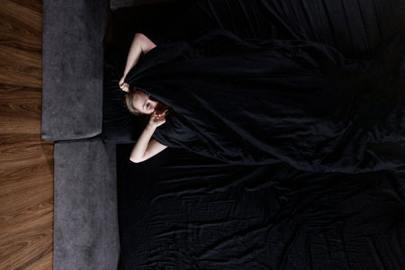 Woman woke up in the morning in a comfortable bed with a silky bed.の写真素材