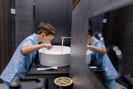 Cute little boy brushing his teeth in the bathroom.の写真素材