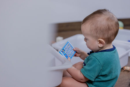 A young baby is happily playing with colorful toys, enjoying their exploration and interactionの写真素材