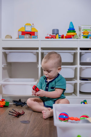 A young baby is happily playing with colorful toys that are kept inside a clean white bin, enjoying their exploration and interactionの写真素材