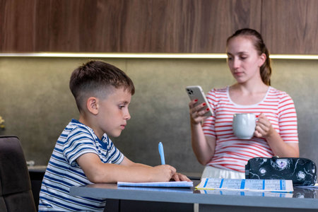 Mother Helping Son With Homework At Table.の写真素材