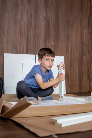 A young boy is diligently working on furniture, applying focus and care to his task.の写真素材