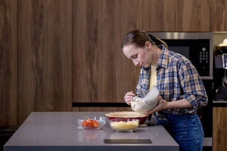 Young woman preparing quiche in the kitchen.の写真素材