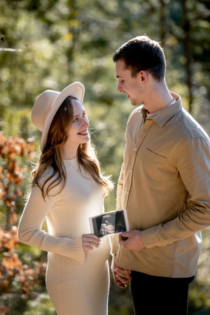 A Couple Joyfully Celebrating Their Pregnancy Announcement Surrounded by Beautiful Nature.の写真素材