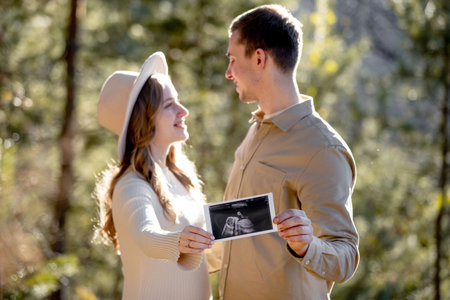 A Couple Joyfully Celebrating Their Pregnancy Announcement Surrounded by Beautiful Nature.の写真素材