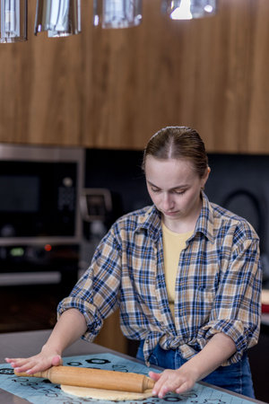Woman skillfully rolls out dough, perfectly showing her culinary expertise in a kitchen.の写真素材