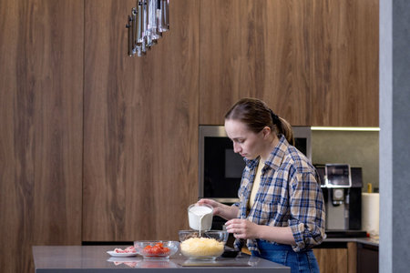 Young woman preparing quiche in the kitchen.の写真素材