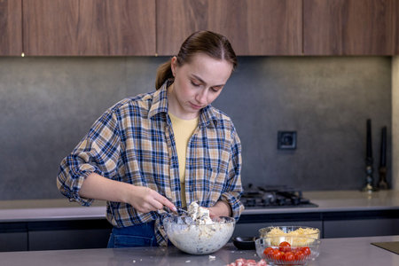 Young woman preparing quiche in the kitchen.の写真素材
