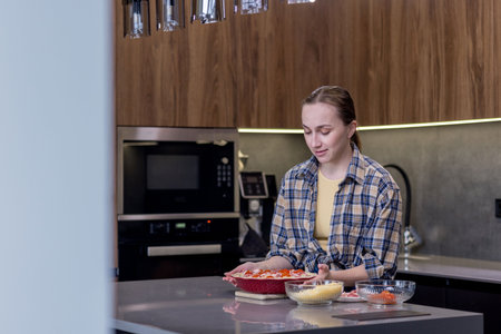 Smiling Woman in Kitchen Showing Freshly Baked Quiche Lorraine.の写真素材