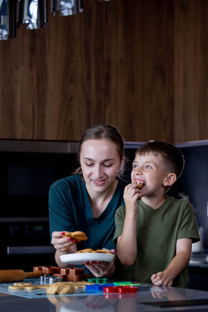 Mother and her son eating freshly baked gingerbread together.の写真素材