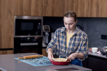 Woman skillfully rolls out dough, perfectly showing her culinary expertise in a kitchen.