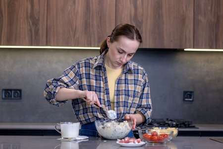 Young woman preparing quiche in the kitchen.の写真素材