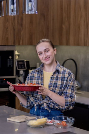 Smiling Woman in Kitchen Showing Freshly Baked Quiche Lorraine.の写真素材