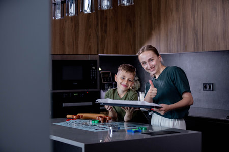 Mother and son bond over making gingerbread in their stylish kitchen.の写真素材