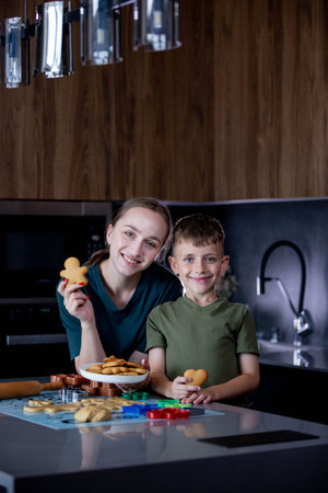 Mother and her son eating freshly baked gingerbread together.の写真素材