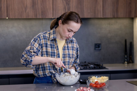 Young woman preparing quiche in the kitchen.の写真素材