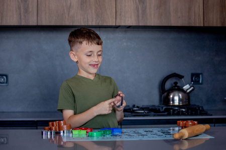 A Child Engaging in Baking Fun with Colorful Cookie Cutters in a Modern Kitchen Space.の写真素材