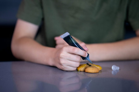 A closeup of a person decorating cookies with colorful icing, highlighting their creativity and baking skillsの写真素材