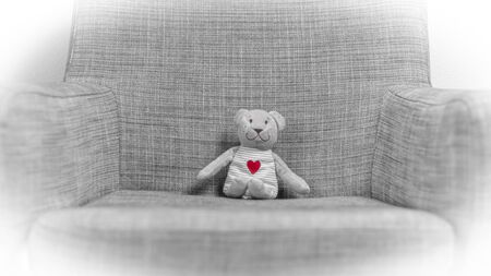 Soft toy small bear with red heart on gray backgroundの写真素材