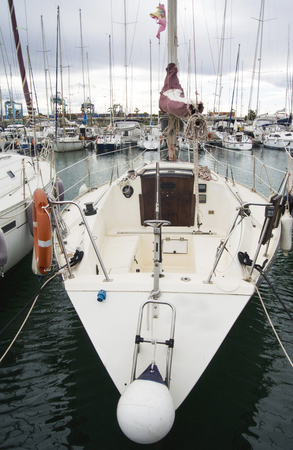 Boat In Valencia Port At Mediterranean Sea. Reflexion in the water. White yacht are in the Spanish port of Valencia in the beginning of spring. Cloudy sky.の写真素材