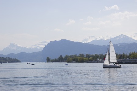 Ship in front of snow covered Alps mountains peaks on Lake Lucerne, central Switzerland. The boat sails along the lake.の写真素材