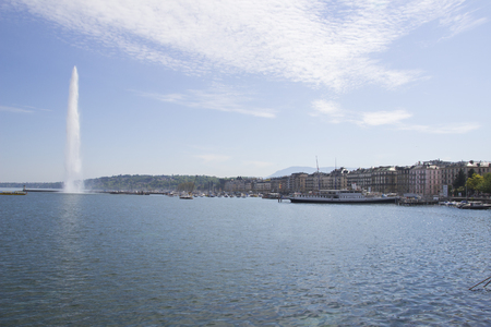 Beautiful view of the water jet fountain in the lake of Geneva, Switzerland. Geneva cityscape with its famous Jet d'Eau fountain on Geneva lake on a sunny summer day in Switzerlandの写真素材
