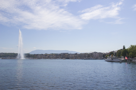 Beautiful view of the water jet fountain in the lake of Geneva, Switzerland. Geneva cityscape with its famous Jet d'Eau fountain on Geneva lake on a sunny summer day in Switzerlandの写真素材