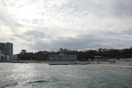 Cloudy weather. Golden sand, waves and foam. Cloudy day on the sandy beach. Panoramic view of beautiful sandy beach. Beach and waves with gloomy skyの写真素材