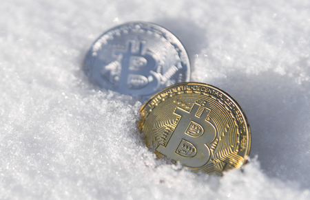 Bitcoins. Cryptocurrency on snow, in the background. The concept of freelancing, the stock exchange. Bitcoins on cold winter snow background. Frozen bitcoins. Frozen account. Cryptocurrency trading.の写真素材