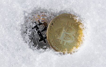 Bitcoins. Cryptocurrency on snow, in the background. The concept of freelancing, the stock exchange. Bitcoins on cold winter snow background. Frozen bitcoins. Frozen account. Cryptocurrency trading.の写真素材
