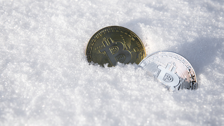 Bitcoins. Cryptocurrency on snow, in the background. The concept of freelancing, the stock exchange. Bitcoins on cold winter snow background. Frozen bitcoins. Frozen account. Cryptocurrency trading.の写真素材
