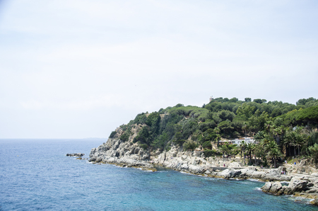Panorama of Rocks on the coast of Lloret de Mar in a beautiful summer day, Costa Brava, Catalonia, Spain. Waterfront of Lloret de Mar Costa Brava Spain. Rocks on the coast of Lloret de Mar.の写真素材