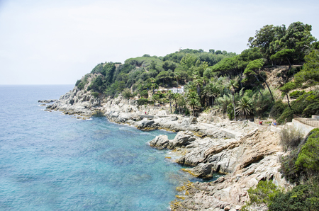 Panorama of Rocks on the coast of Lloret de Mar in a beautiful summer day, Costa Brava, Catalonia, Spain. Waterfront of Lloret de Mar Costa Brava Spain. Rocks on the coast of Lloret de Mar.の写真素材