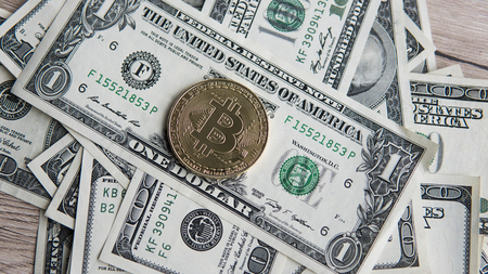 Golden Bitcoins on US dollars. Digital currency close-up. New virtual money. Crypto currency top view. Real coins of bitcoin on banknotes of one hundred dollars. Exchange. Bussiness, commercial.の写真素材